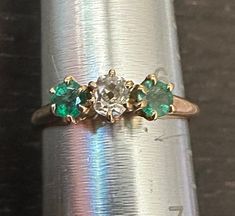 Antique 14K Emerald & Diamond ring size 6, weight 2.2 grams.  Antique old white European cur center Diamond(4mm-approx 1/4 carat) with two genuine richly colored deep green Emeralds on each side-High prong setting.  The classic trinity horizontal design. Classic Green Multi-stone Diamond Ring, Vintage Emerald Ring With Rose Cut Diamonds, Vintage Style Emerald Cluster Ring In Yellow Gold, Vintage Emerald Ring With Prong Setting, Antique Green Ring With 17 Jewels, Vintage Green Emerald Ring With Rose Cut Diamonds, Emerald Cluster Ring With Rose Cut Diamonds, Vintage Green Cluster Ring For Formal Occasions, Antique 14k Stamped Emerald Anniversary Ring