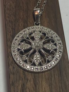 "This is a beautiful vintage, genuine, natural diamonds and sterling silver floral necklace. The necklace is 18 inches. The round disc pendant is just so sparkly and gorgeous with 21 round-cut, prong-set diamonds that make a flower design. The pendant measures about 1 1/4\" by 7/8\" (About 7/8\" in diameter without the bale). So well-made and striking when worn. The pendant and chain are both stamped 925 with a heart logo and weigh about 3.6 grams. Beautiful! See pictures for detail.  More gorgeous jewelry here, and some on BIG clearance in my shop:  www.etsy.com/shop/BargainBitz Please Note: The display model is not human size and is just meant to show the details of the piece. Please refer to the exact measurements in the listing for size." Sparkling Round White Gold Diamond Necklace, Sparkling White Gold Round Diamond Necklace, Celebration Sterling Silver Diamond Necklace In White Gold, Sterling Silver Diamond Necklace In White Gold For Celebration, White Gold Sterling Silver Diamond Necklace For Celebration, Anniversary Diamond Necklace With Intricate Design, Vintage Diamond Necklace With Diamond Accents As Gift, Vintage Round Diamond Necklace For Anniversary, Classic Sparkling Diamond Necklace For Anniversary