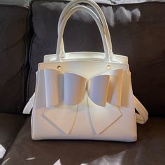 New Without Tags. Romantic, Elegant White Leather Satchel. Gold Tone Accents And Removable Shoulder Strap. White Satchel Evening Bag, White Double Handle Satchel As Gift, Chic White Handheld Bag, White Party Satchel Bag, White Top Handle Satchel As Gift, White Top Handle Satchel For Gift, White Shoulder Bag Satchel For Gift, White Satchel Shoulder Bag For Gift, White Satchel Shoulder Bag As Gift