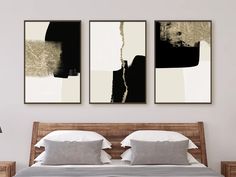 two black and white paintings hanging above a bed