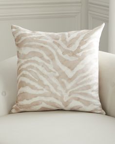 a zebra print pillow sitting on top of a white couch