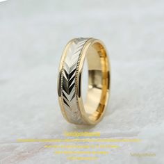 a wedding ring with an engraved design on the inside and outside, sitting on a white surface