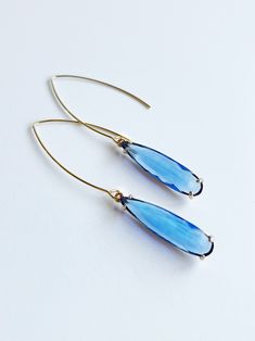 Blue Pendant Earrings ⟡ all items are designed and handcrafted in our studio ⟡ Long blue glass and gold teardrop earrings. These stunning teardrop earrings feature a beautiful blue glass stone set in a gold plated over brass setting, adding a pop of color and luxury to any outfit. The long ear wire adds a simple yet dramatic look that can be dressed up or down for any occasion. OVERVIEW-3" in length-glass crystals-gold plated over stainless steel ear wiresLooking for more threader earrings? Clic Elegant Blue Drop Crystal Earrings, Blue Teardrop Crystal Earrings With Ear Wire, Blue Long Drop Teardrop Earrings, Blue Drop Earrings With Ear Wire, Blue Teardrop Crystal Earrings, Blue Long Drop Teardrop Earrings For Pierced Ears, Blue Teardrop Crystal Earrings For Pierced Ears, Sapphire Teardrop Crystal Earrings, Formal Teardrop Wire Wrapped Earrings