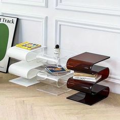 a stack of books sitting on top of a wooden floor next to a white wall