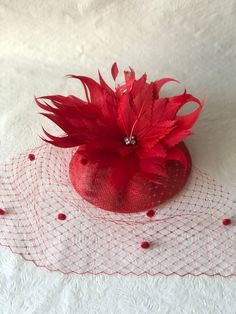 Red feather flower mini fascinator hat with dotted veil perfect for Kentucky Derby, hat for races, Tea party hat, Wedding hat, Mother of the bride hat, cocktail dinner, or any other special occasion. *Easy to wear *Lightweight *Worn on either side This is a fiery red sinamay fascinator free-formed with handmade feather flower and adorned and adorned with chenille dot to give a vintage appeal. Love what you see would like a different color? Please feel free to send a message we'd love to create a Red Flower Fascinator For Party, Red Spring Event Fascinator, Luxury Fitted Red Fascinator, Red Spring Fascinator Headband, Red Feathered Hat Fascinator, Mother Of The Bride Hats, Red Fascinator, Sinamay Fascinator, Kentucky Derby Fascinator