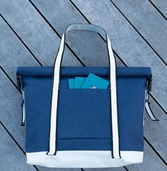 a blue and white tote bag sitting on top of a wooden floor next to a pair of scissors