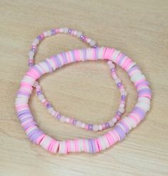 two pink and purple beads on a wooden table