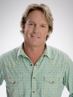 a man in a green shirt is posing for a photo with his hands on his hips