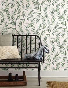 a black bench sitting in front of a wall with green leaves on it