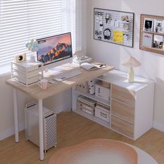 a desk with a computer on top of it in front of two pictures and a lamp