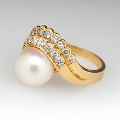 This elegant ring is centered with one (1), post set, cultured saltwater pearl. The pearl is accented to one side with sixteen (15), semi-bezel/bead set, round brilliant cut diamonds. The ring measures 15.3mm at the top, rises 11.0mm above the finger, tapering to 2.4mm wide and 0.9mm thick at the base of the shank. This ring is currently a size 7. Timeless Pearl Ring With Diamond Accents For Anniversary, Elegant Pearl Ring With Diamond Center Stone, Timeless Anniversary Pearl Ring With Diamond Accents, Timeless Diamond-white Pearl Ring With Diamond Accents, Luxury Pearl Ring With Diamond Accents For Anniversary, Timeless Diamond White Pearl Ring With Diamond Accents, Pearl White Diamond Pearl Ring With Drop Detail, Timeless Diamond Pearl Ring With Center Stone, Pearl White Diamond Ring With Pearl Drop