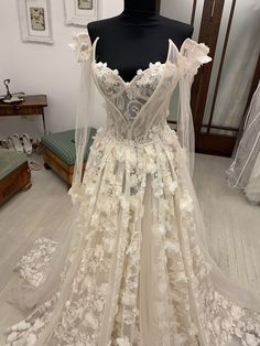 a white wedding dress on display in a room