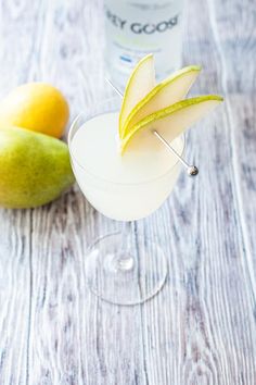 an apple and pear martini garnished with toothpicks on a wooden table