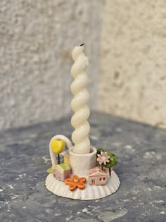 a small white candle sitting on top of a table