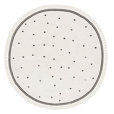 a round rug with black dots on white paper and fringe trim around the edges is shown