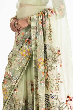 Elevate your style with our olive green organza sari blouse. This blouse is delicately embroidered with multicolored resham, beads, and sequins, adding a vibrant and eye-catching touch to your ensemble. It's the perfect choice for a touch of sophistication and charm in your attire. Bridgerton Theme, Floral Sari, Organza Sari, Special Outfits, Suit Styles, Designer Kurti Patterns, Kurti Patterns, Green Lehenga, Borders Design