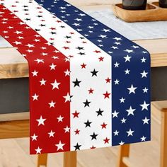 an american flag table runner with red, white and blue stars in the center on a dining room table