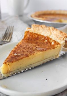 a piece of pie sitting on top of a white plate next to a silver fork