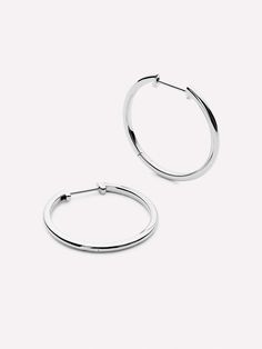 Because hoops never go out of style, we decided to make these medium slim endless hoops for all our silver savants. These hoops are crafted in sterling silver and dipped in a layer of rhodiumso theyre sleek, slender, and always shiny. Wear these medium slim endless hoops with our Mini Huggie Hoops Silver to complete your stack. If silver isnt your thing, try our original Lo Medium earrings!  Crafted in sterling silver  Finished in rhodium  365-day warranty Simple Silver Earrings, Hoops Silver, Detailed Jewelry, Letter Necklace, Online Jewelry Store, Recycled Sterling Silver, Go Out, Out Of Style, Jewelry Care