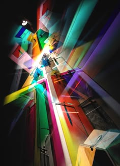 an abstract photo with multicolored lines and light coming from the ceiling in front of it