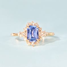 an engagement ring with a blue and white diamond surrounded by two yellow gold diamonds on the band