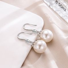 Regally divine, these pearl drop earrings are a tasteful addition to her jewelry box. Created in sterling silver, each beautiful earring showcases a beguiling 12mm white cultured pearl and shimmering white stones. With ease and elegance, these classic pearl drop earrings complete her tailored anytime attire.Width: 12 mmHeight: 30 mmThickness: 12 mmMaterial: 925 SilverPlating Color: Silver Elegant Pearl White Earrings With Pearl Chain, Elegant Pearl White Pearl Chain Earrings, Pearl White Jewelry For Formal Occasions, Elegant Pearl White Earrings With Pearl Drop, Elegant Silver Earrings With Pearl Chain, Elegant Pearl White Pearl Drop Earrings, Graceful Pearl White Earrings, Graceful Pearl White Pearl Earrings, Elegant Pearl White Earrings With Pearl Charm