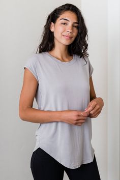 A classic boyfriend bamboo tee with a feminine twist. This universally flattering style can be worn with skirts, pants, or leggings and is a perfect base for any wrap or jacket. Scoop neck, cap sleeve, relaxed fit. High-low curved hemline. Below hip length. Boyfriend Tshirt, Witchy Boho, Silk Clothing, Cap Sleeve Shirt, Silk Outfit, Wrap Jacket, Boho Luxe, Sustainable Style, Long Torso