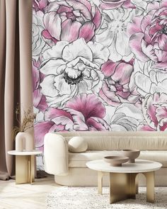 a living room with pink flowers on the wall and white couches in front of it