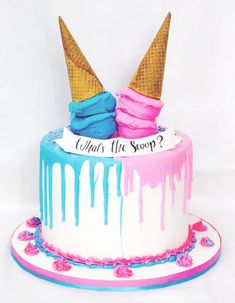 two ice cream cones on top of a cake with blue and pink icing dripping down the sides