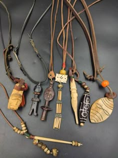 an assortment of necklaces are displayed on a gray surface, including beads and other items