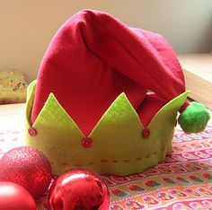 a red hat sitting on top of a table next to ornaments