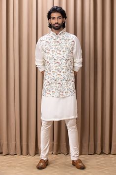 Off white nehru jacket with floral hand painted digital prints.
Component: 1
Pattern: Digital Print
Type Of Work: Floral Patterns
Neckline: Mandarin Collar
Sleeve Type: Sleeveless
Fabric: Cotton Silk, Lining: Twill Satin
Color: Off White
Other Details: 
Note: Kurta and pant worn by the model is not for sale
Occasion: Sangeet - Aza Fashions Nehru Jacket For Men, Nehru Jacket, Nehru Jackets, Satin Color, Kurta Set, Jackets Online, Floral Patterns, Mandarin Collar, Cotton Silk