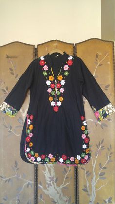 "80s Unusual black tunic Indian dress. Medium length sleeves with floral cuffs. Long splits up sides. Small stand up collar and deep V which is trimmed in floral fabric. Colourful embroidered flowers with little mirror centres around hem and sides and down the v neck sides. Made in India Size label says 40 however the bust is more a small 36 Bust 34 / 36 small Sleeves 19 inches Shoulders 14 1/2 inches Length 33 1/2 inches Waist 34\" Hips 38inches" Spring Long Sleeve Kurta With Embroidered Cuffs, Spring Kurta With Embroidered Cuffs And Long Sleeves, Spring Bohemian Kurta With Mirror Work, Bohemian Spring Kurta With Mirror Work, Bohemian Kurta With Mirror Work For Spring, Fitted Kurta With Embroidered Sleeves For Spring, Spring Floral Print Kurta With Multicolor Embroidery, V-neck Kurta With Floral Embroidery For Spring, Spring V-neck Kurta With Floral Embroidery