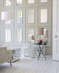 a living room filled with white furniture and walls covered in glass blocks, including a lamp