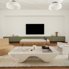 a living room with white furniture and a flat screen tv mounted above the entertainment center