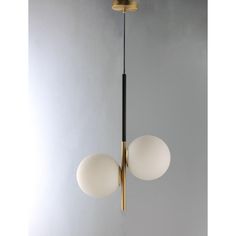 two white balls hanging from a brass colored light fixture on a gray wall with grey background