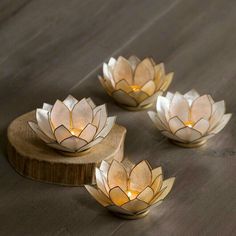 three lit candles sitting on top of a wooden table