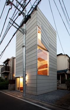 a white building with windows on the side and power lines in the air above it