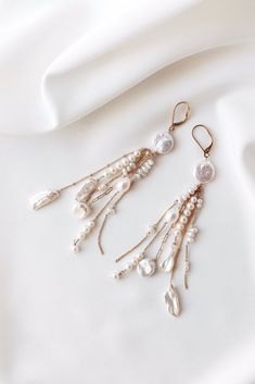 ❄️ Production times have now been extended due to the holidays, please check the estimated delivery date in your cart before ordering. If you need an order sooner than is stated please contact me to see if it will be possible. ❄️ Elevate your bridal ensemble with these exquisite long dangly boho luxury earrings. Handcrafted with meticulous care and quality materials, these earrings feature a stunning combination of 14k filled gold chain and a curated mix of freshwater pearls, ensuring a unique a Bohemian Bridal Earrings For Wedding, Bohemian Pearl Earrings With Dangling Beads For Weddings, Elegant Long Drop Chandelier Earrings With Dangling Charms, Bohemian Wedding Pearl Drop Earrings, White Long Drop Bridal Earrings For Wedding, Elegant Wedding Jewelry With Dangling Beads, Bohemian Pearl Drop Earrings For Wedding, Bohemian Pearl Earrings For Wedding, Silver Jewelry With Dangling Charms For Wedding