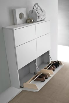 there is a shoe rack with shoes on it in front of a white cabinet and door