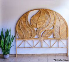 a bamboo headboard sitting on top of a tiled floor next to a potted plant