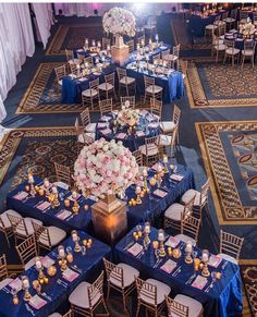 the tables are set up with blue linens and white flowers in centerpieces