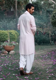 The jalalgarh kurta in powder pink is a charming and sophisticated choice for Indian grooms, ideal for haldi, mehndi, or sangeet ceremonies. Crafted from a luxurious blend of viscose cotton silk and georgette, this kurta offers a smooth and breathable feel, perfect for long celebrations. The kurta comes with an ivory salwar, creating a balanced and harmonious ensemble. The jalalgarh kurta is perfect for grooms who want a contemporary yet traditional outfit. Pair it with traditional juttis or modern footwear for a polished and sophisticated appearance. Pink Nehru Jacket For Festive Occasions, Pink Straight Kurta With Cutdana, Pink Bandhgala With Dabka Work, Pink Nehru Jacket For Diwali With Traditional Drape, Festive Pink Nehru Jacket Straight Kurta, Pink Bandhgala With Dabka Work For Eid, Pink Cotton Sherwani With Resham Embroidery, Pink Kurta With Chikankari Embroidery For Transitional Season, Transitional Pink Kurta With Chikankari Embroidery