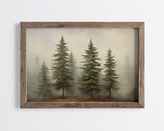 a painting of trees in the fog on a white wall with a wooden framed frame