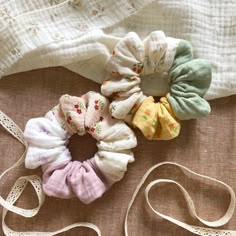 four small scrunffles sitting on top of a bed next to a white bag