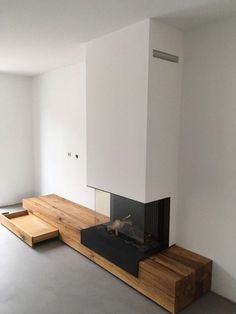 an empty room with a fireplace and benches