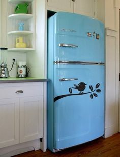 a blue refrigerator sitting in the middle of a kitchen