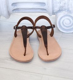 "SKOPELOS is named after a Greek island, and it's a T-strap sandal with a buckle closure lower than the ankle. A classic design, that many purchase year after year, in multiple colours. Wear it day or night, with any outfit, be it a pair of summer print pants, chinos, shorts, jeans, skirt, or dress. A true wardrobe staple, weather you are planning to visit a Greek island, or not! ALL ORDERS ARE SHIPPED VIA TNT EXPRESS WORLDWIDE (Please include a phone number at checkout, as it's required by the Brown Toe Post T-strap Sandals For Vacation, Brown T-strap Sandals With Single Toe Strap For Vacation, Brown T-strap Sandals With Single Toe Strap For Summer, Brown T-strap Sandals With Leather Sole, Summer Brown T-strap Sandals With Single Toe Strap, Brown T-strap Sandals For Summer, Brown T-strap Flip Flops For Beach, Brown Ankle Strap T-strap Sandals With Heel Loop, Brown T-strap Slingback Sandals With Leather Sole