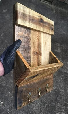 a hand holding a wooden box that is made out of wood