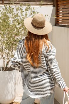 Stay cool and stylish this summer with our Zuma Button Down, featuring pretty iridescent buttons and a raw hem. This super lightweight top offers an effortless, relaxed, and roomy fit, making it perfect for warm weather. Best of all? Its 100% cotton! Wear it buttoned up for a polished look or unbuttoned over a swimsuit or tank for a breezy, casual vibe. This versatile piece is a must have summer staple! Malibu Collection FIT Relaxed Roomy Fit Iridescent Buttons High-Low Raw Hem Clancy is 5'9 Wea Casual Shirt For Beach In Fall, Casual Beach Shirt For Fall, Casual Shirt For Beach And Fall Season, Striped Summer Shirt For Day Out, Striped Summer Blouse For Day Out, Chic Striped Shirt For Beach, Striped Button-up Beach Shirt, Striped Shirt With Button Closure For Beach, Chic Vacation Tops With Button Closure